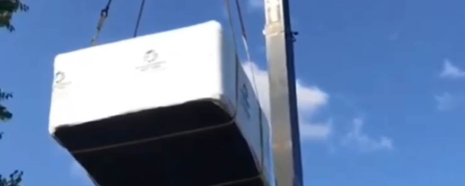 crane lifting hot tub over house